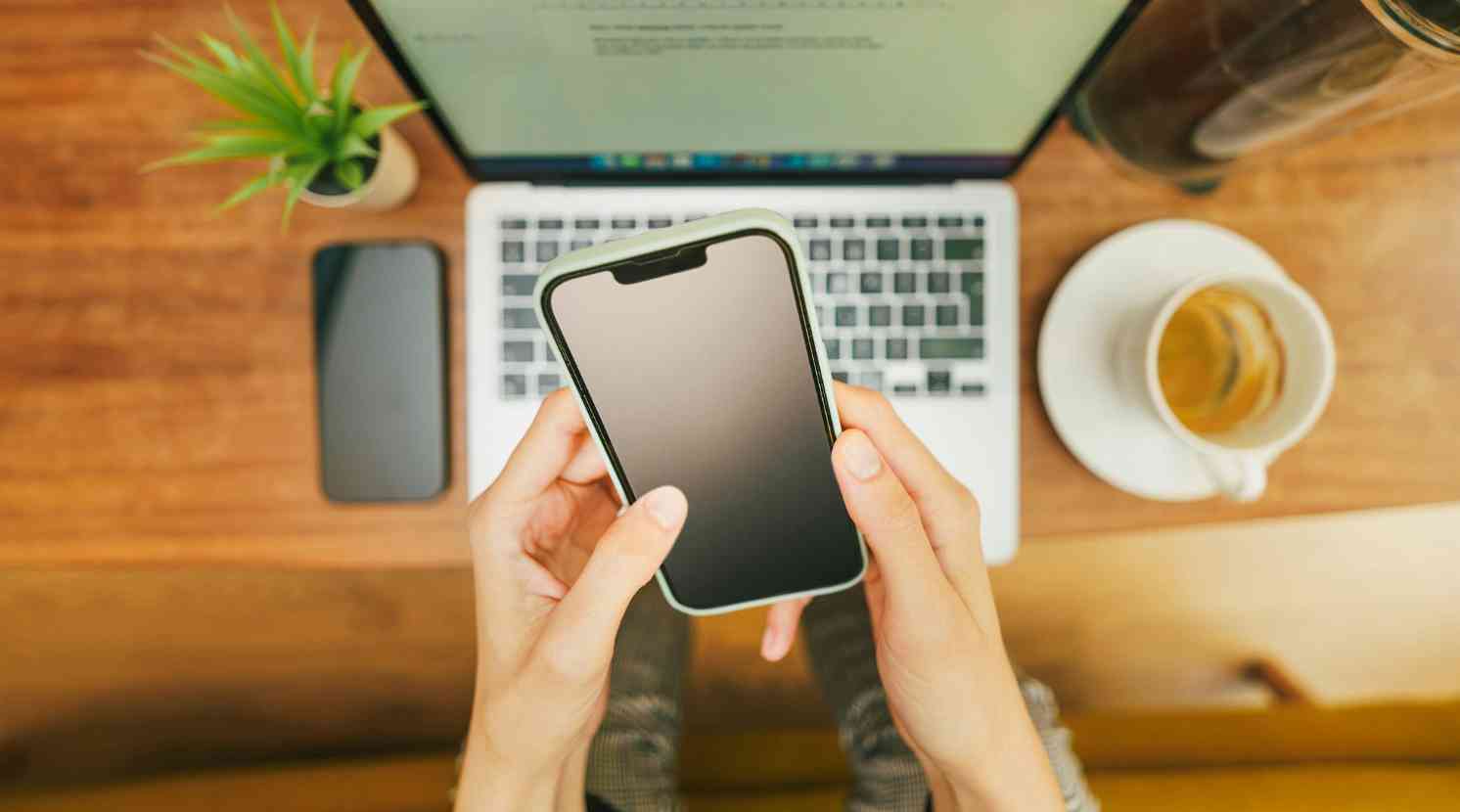 Mann sitzt auf der Couch am Laptop und hat Kopfhörer auf